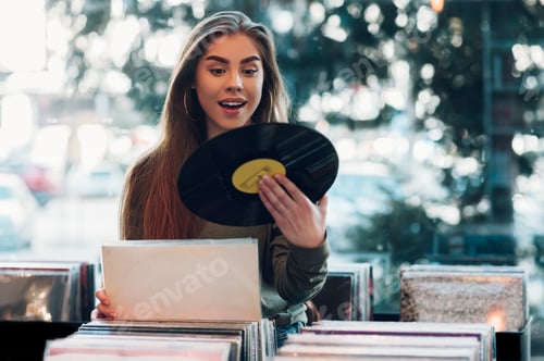Preview: Woman holding vinyl while choosing record in a music shop.