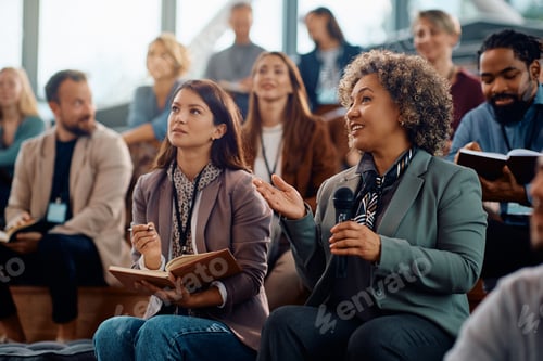 Preview: Female manager asking question from the audience while participating in business seminar.