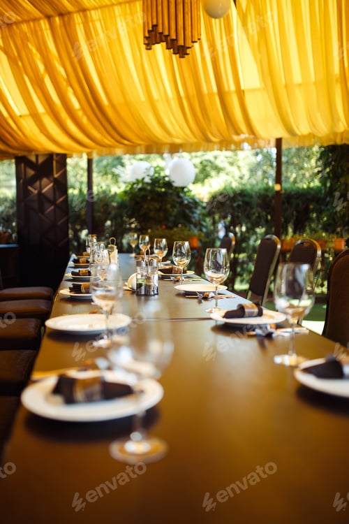 Preview: Sparkling glassware stands on long table prepared for wedding dinner.