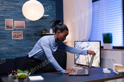 Preview: Dark skinned business woman using laptop