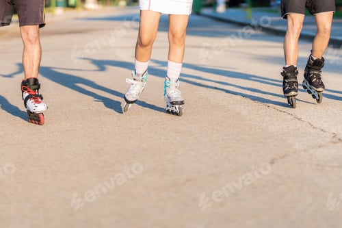 Preview: Legs of people on inline skates skating without protection on a street