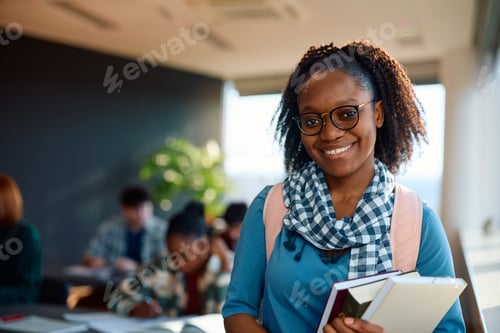 Preview: Happy black female student at college classroom looking at camera.