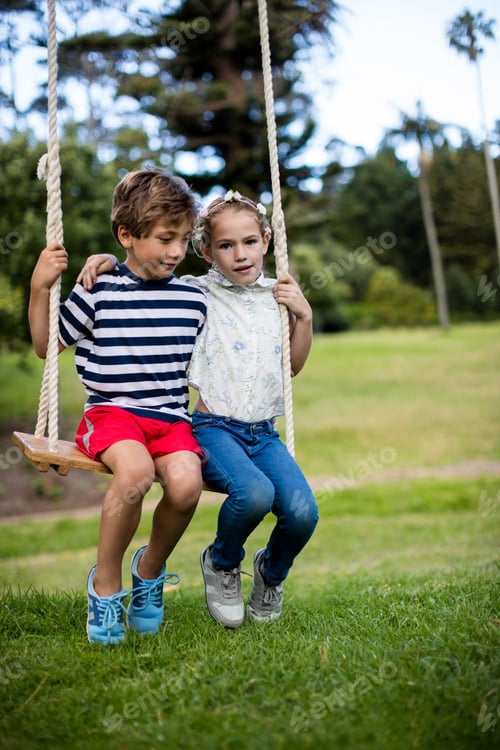 Preview: Boy and girl sitting on a swing in park