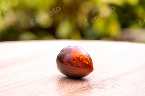 Preview: fresh picked multicolored striped and streaky black, purple, and red tomatoes on a wooden table