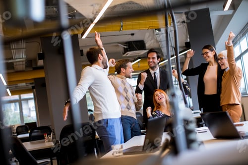 Preview: Happy young business people standing in the office and looking forward to success in the office