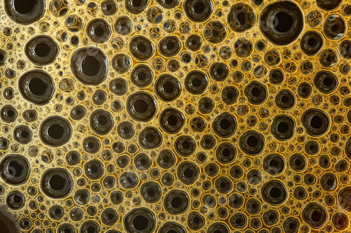 Preview: Close up of a cup of black coffee. Milk in coffee close-up top view.