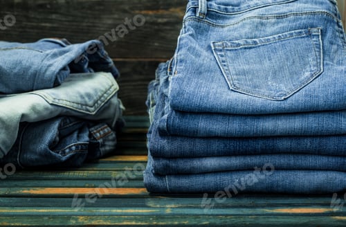 Preview: bunch of jeans on wooden background, fashionable clothes