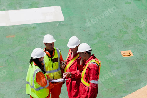 Preview: Construction workers in a meeting at a job site.
