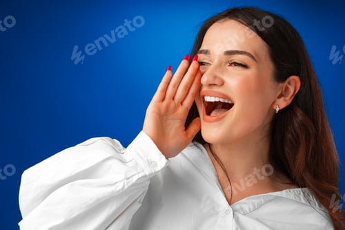 Preview: Crying emotional young woman screaming on blue studio background