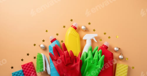 Preview: Cleaning tools and Christmas decorations in santa hat top view flat lay on orange background