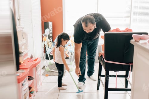 Preview: Girl sweeping kitchen floor, father watching