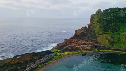 Preview: Summer rocky coastline formation on cloudy day. Flight over endless sea water