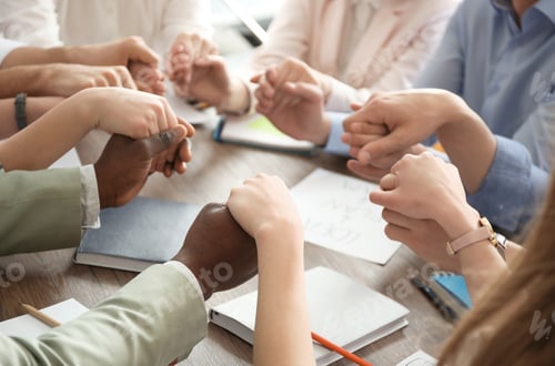 Preview: People holding hands together at table. Unity concept