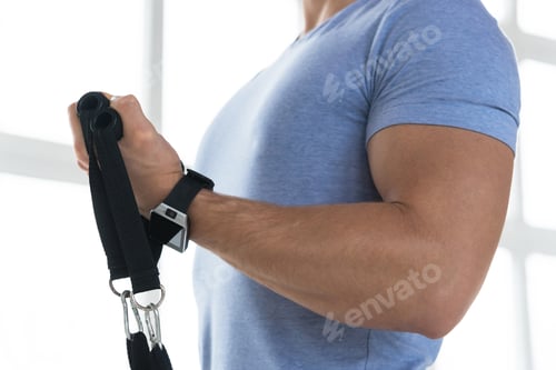 Preview: Young man during workout with a resistance bands in the gym