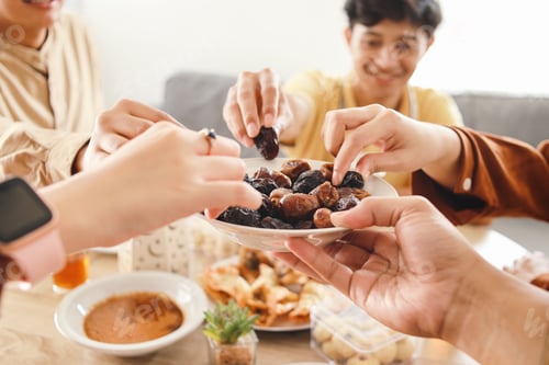Preview: Muslim Friends Take a Dates Fruit on Bowl During Breakfasting Ramadan