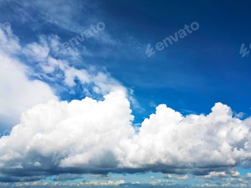 Preview: Fluffy white clouds in a vibrant blue sky.