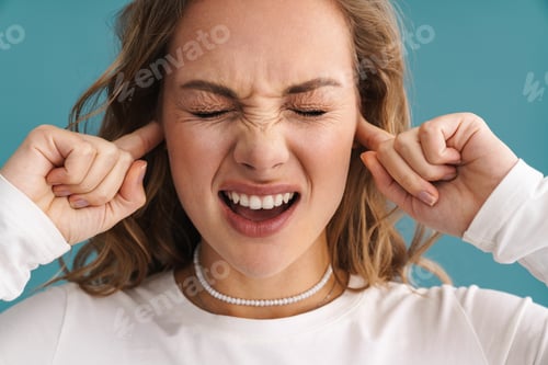 Preview: Blonde displeased woman plugging her ears and frowning