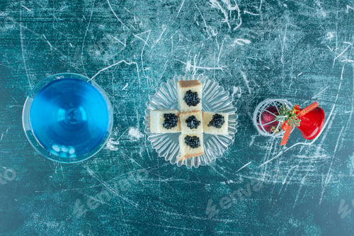 Preview: A glass cup of blue drink with pastries