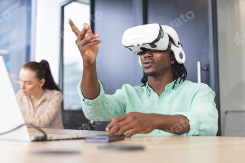 Preview: African American man wearing VR headset and pointing in modern business office