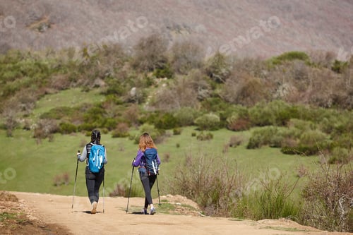 Preview: Two female backpacker hikers on a pathway. Mountain trekking. Copyspace