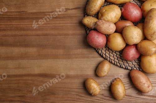 Vista previa: Composición plana con patatas orgánicas frescas sobre fondo de madera