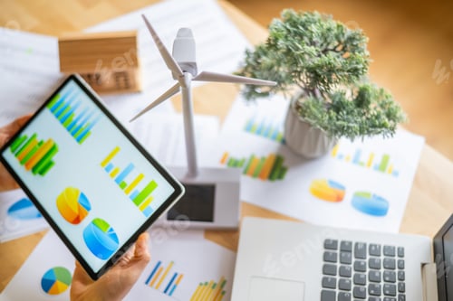 Preview: Businesswoman analyzing data on a digital tablet with charts renewable energy investments