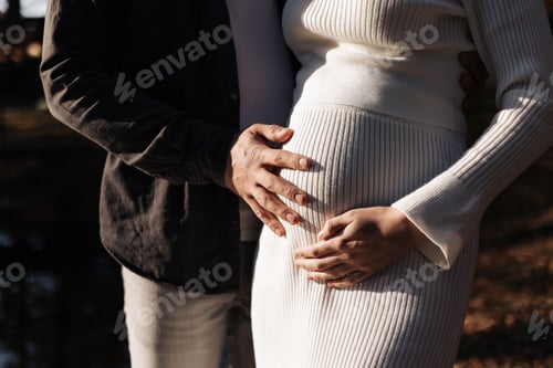 Preview: Family day. Stylish unrecognisable marriage pregnant couple waiting for baby. Man is hugging