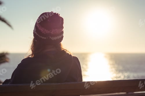 Preview: Woman watching the sunset in winter