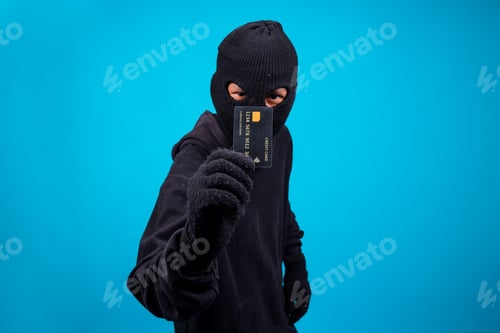 Preview: Burglar Wearing Mask Holding Credit Card Over Blue Background