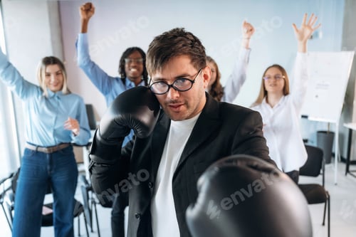 Preview: Punching, in boxing gloves. Group of young business people are in conference room