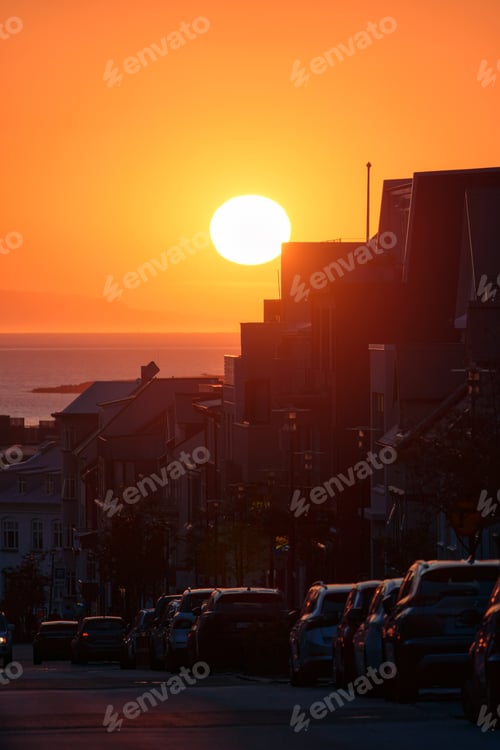 Preview: Sunset over building and car parking on the roadside in downtown