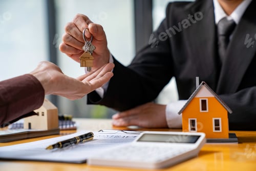 Preview: Real estate agent giving key from new house to young man in office