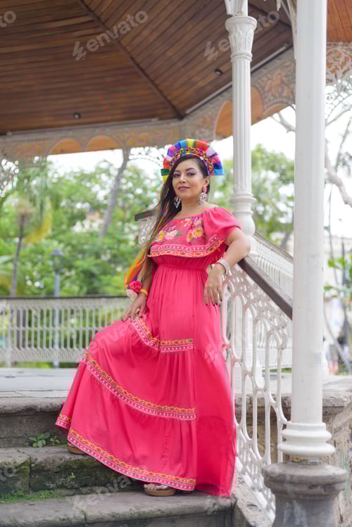 Mexican woman wearing traditional dress with multicolored embroidery celebrating independence day.