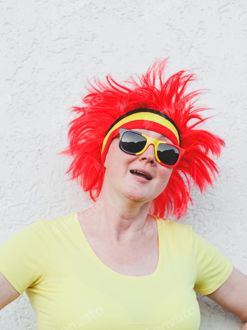 Preview: Portrait of a caucasian blonde woman with a Belgian flag wig with red hair and sunglasses