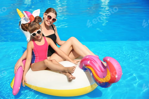 Preview: Mother and daughter on inflatable mattress in swimming pool. Family vacation
