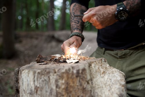 Preview: Man igniting a fire on tree stump in the forest