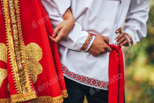 Preview: A guy and a girl dressed in national Russian clothes are holding hands Art grain and noise on photo