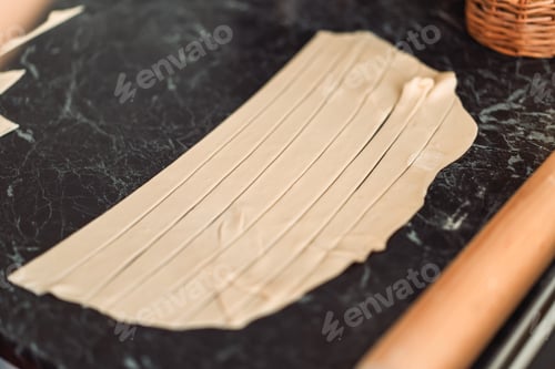Preview: Puff pastry cut into strips on a tabletop