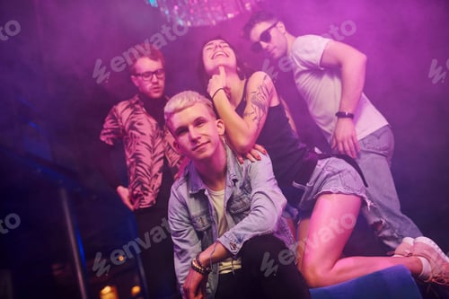Preview: Young people is having fun in night club with colorful laser lights