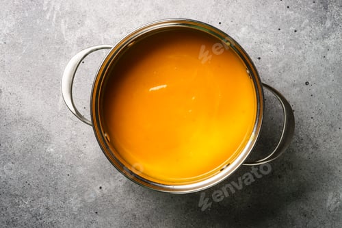 Preview: Pumpkin soup in the pot at stone table.