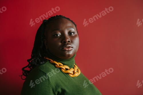 Preview: Portrait of beautiful plus size African woman looking at camera on red background