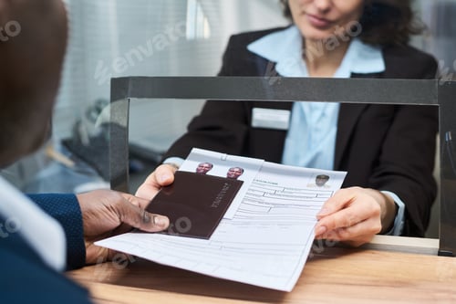 Preview: Middle Aged Woman Handing Documents to Black Man at Visa Center Counter