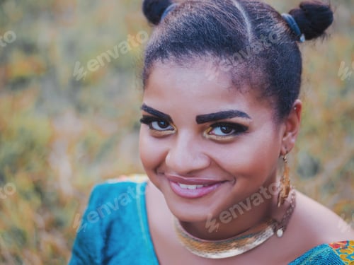 Preview: Beautiful Afro American woman in colorful dress posing outdoors