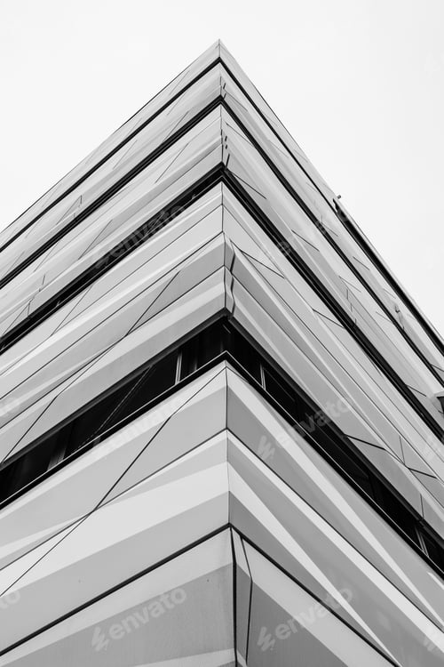 Preview: Low-angle shot of an exterior of a modern multi-storey building, featuring a variety of windows
