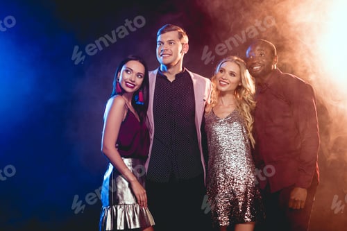 Preview: beautiful smiling multiethnic friends hugging on party with smoke