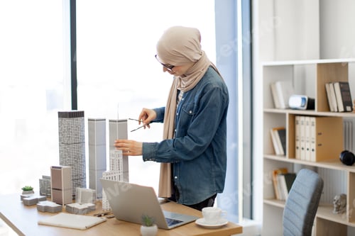 Preview: Lady using compass and laptop in architecture office