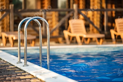 Preview: Top view of swimming pool with clear water on vacation on sunset background