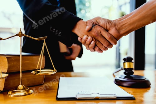 Preview: Male lawyer with client shaking hands in office
