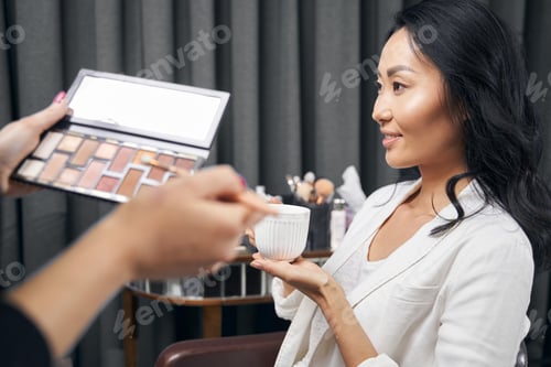 Preview: Happy cheerful woman with dark hair after the makeup procedure in parlor