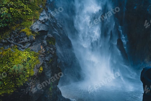Preview: Aerial view of waterfall flowing from rocks surrounded by cliffs